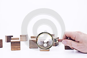 Scattered wooden cubes on a white background. Blocks. Magnifying glass. Research and meticulousness. Detective