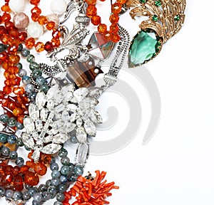 A scattering of antique jewelry with copy-space. Corals, glass, emeralds, bone