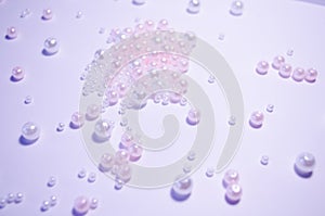 A scattering of beads close-up. White. Transparent. beads of different sizes. Beads on a white background. Materials for jewelry