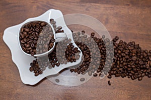 A scattering of coffee beans white cup and saucer