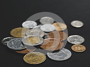 A scattering of coins on a black background