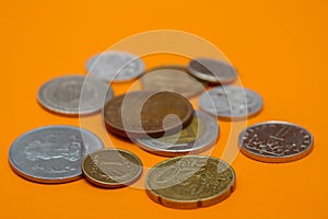 A scattering of coins on the orange background