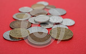 A scattering of coins on the red background