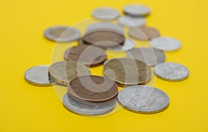 A scattering of coins on the yellow background