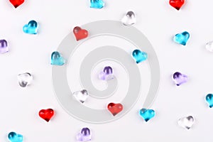 A scattering of colored glass hearts on white background for Valentine`s Day