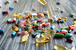 Scattering of colorful pills on wooden table