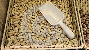 A scattering of peanuts and a scoop on the counter of a vegetable store.