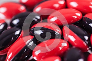 A scattering of red-black brown pills on the mirror background