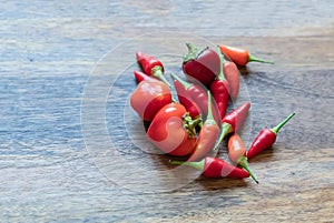 Scattering of red chili peppers and hot on a wooden background close-up