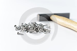Scattering small iron nails with hammer isolated on white background