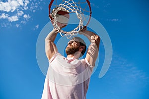 sccessful man dunking basketball ball through net ring with hands, sport hobby