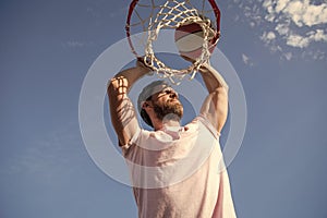 sccessful man dunking basketball ball through net ring with hands, sport hobby
