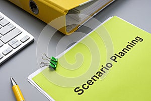 Scenario planning document near a yellow folder.