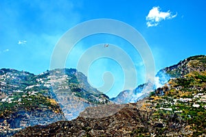 Scene of aerial firefighting in Amalfi with a helicopter dumping water on the mountain photo