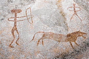 A scene of animal hunting performed ocher on the wall of the cave. photo