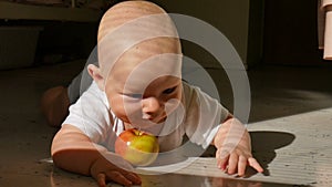 Scene of a beautiful little baby lying on the floor with green and red apple