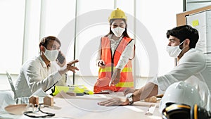 Scene of construction engineers discussing while all of them wearing a surgical mask to protect Coronavirus or Covid-19 spread out