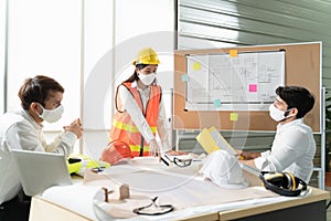 Scene of construction engineers discussing while all of them wearing a surgical mask to protect Coronavirus or Covid-19 spread out