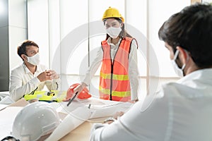 Scene of construction engineers discussing while all of them wearing a surgical mask to protect Coronavirus or Covid-19 spread out