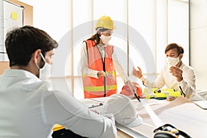 Scene of construction engineers discussing while all of them wearing a surgical mask to protect Coronavirus or Covid-19 spread out