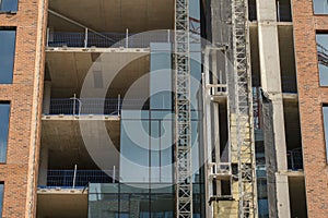 Scene on a construction site of a modern building. Installing windows phase. Building with red classic bricks. Building