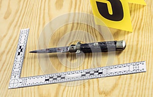 Scene of crime, razor spotted with blood, rule of ballistic measurement, conceptual image