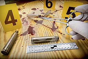 Scene of crime, Scientific police picking up bullet cap with tweezers, rule of ballistic measurement, conceptual image, horizontal