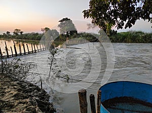 A scene of a fishing trap of bamboo in the river at dusk.