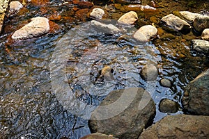 Scene of fresh water stream flow and natural river hard rock with lichen, small wave and light reflection background in Kurokawa