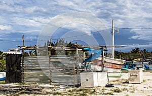 Scene from Mexican fishing marina in the Yucatan during the rainy season - boats and equipment all around