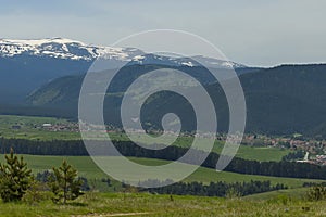 Scene with mountain top, valley and residential district of bulgarian village, Govedartsi, Rila mountain