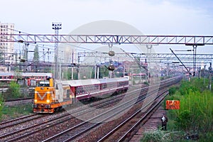 Scene of orange locomotive and red train in Carpati station, Bucharest, CFR