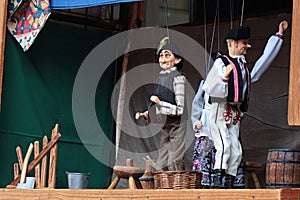 Scene from puppet theater - muddleheaded son and his peasant father.