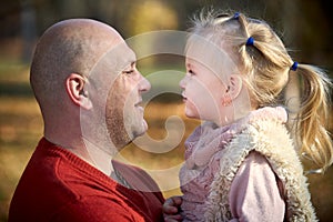 Scene of quiet family happiness filiation and love. Happy caucasian father and his little daughter face to face closely