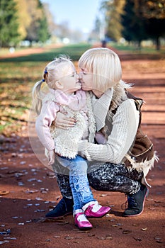 Scene of quiet family happiness and love. Happy caucasian mother holding her little daughter on her laps face to face