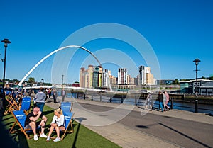 Scene set against the Gateshead Millennium Bridge and the Baltic Centre for Contemporary Art of people enjoying themselves at the