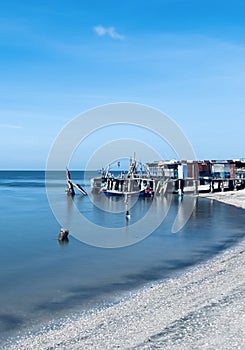 a scene of traditional fishing village and jetty photo