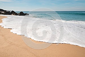 scene of the waves of the Atlantic Ocean reverberating on the sandy beach of Praia da Ilha do Pessegueiro near Porto Covo, western