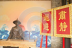 A scene in which an ancient Chinese official sits in a public hall to perform official duties.