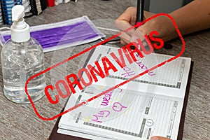 Scene of woman writes the date of her wedding in a personal organizer. stamp canceled by coronavirus. She is sitting at a desk. A