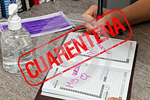 Scene of woman writes the date of her wedding in a personal organizer. stamp quarantine by coronavirus. She is sitting at a desk.