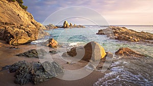 Scenery beach at sunrise. Spanish beach. Rocks and stones on sea shore. Amazing view on sea