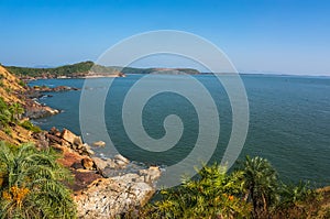 The scenery is beautiful rocky coast, blue sea and cloudless sky. Om beach, Gokarna, Karnataka, India photo