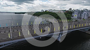 Scenery of bridge road and wide river dividing city on two parts on summer day