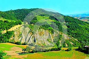 Scenery from Castignano with a hill of ravines and green colours, a valley and the Sibillini