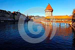 Scenery of Chapel Bridge  Kapellbrucke  and Water Tower bathed in warm golden sunlight over Reuss River in Lucerne Old Town, Swi