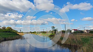 the scenery of the countryside. river, sky, clouds, houses
