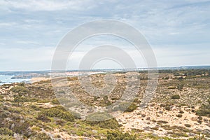 Scenery of the dry steppe in the west of Portugal in the Odemira region. View of fields, city and Atlantic Ocean. Following the photo