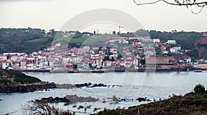 Scenery of houses at the lakeshore in Luanco, Asturias, Spain photo