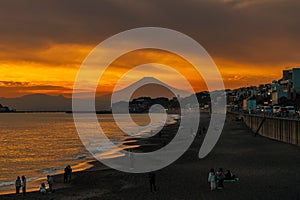 Scenery Kamakura Yuigahama Beach with Kamakura city and Fujisan mountain. Twilight silhouette Mount Fuji behind Enoshima island at